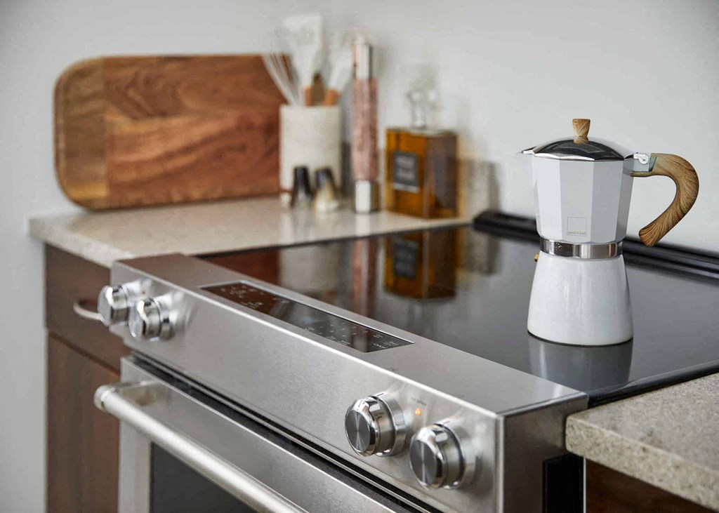 a stainless steel stove top oven with a coffee pot on it