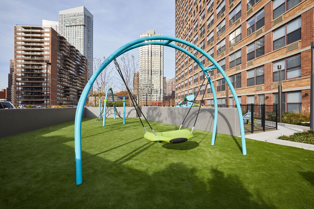 a playground on the roof of a building with a swing set