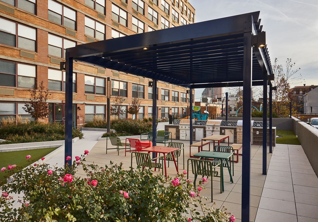 a patio with tables and chairs under a black canopy