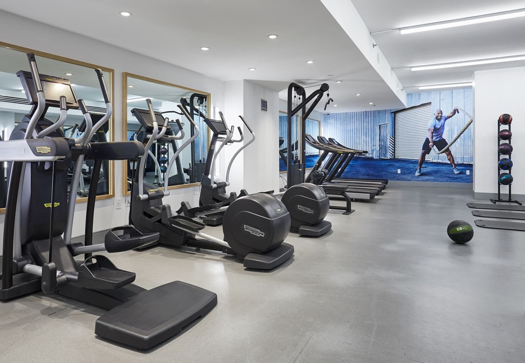 a man working out in a gym with weights and other exercise equipment