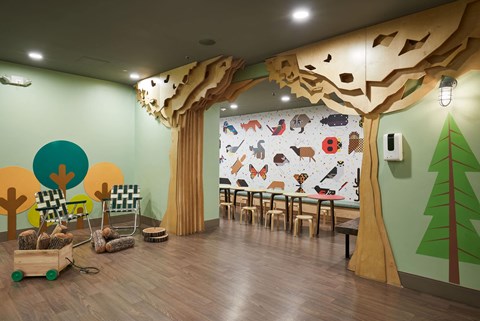 a room with a tree mural and tables and chairs
