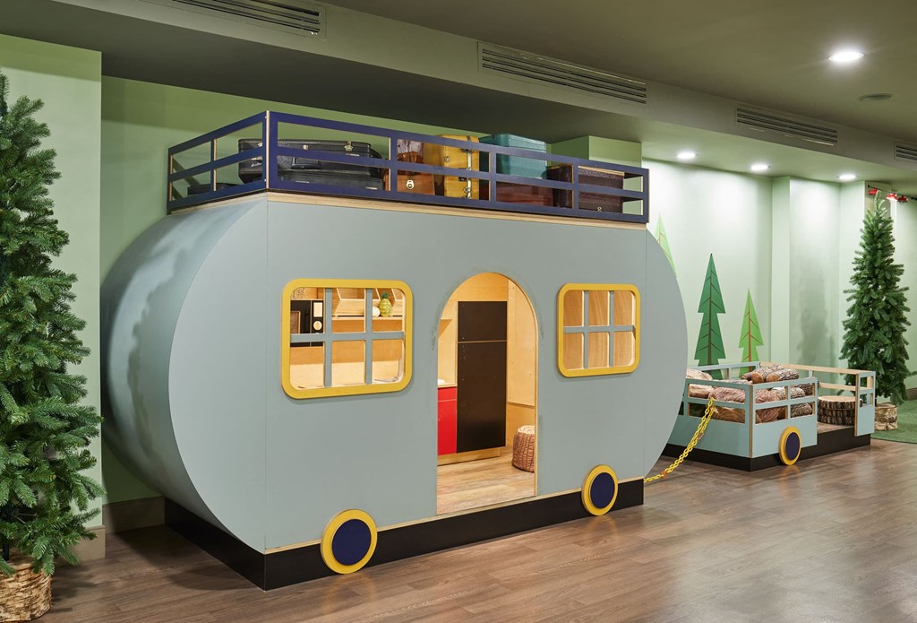 a house shaped like a trailer with a bunk bed on top