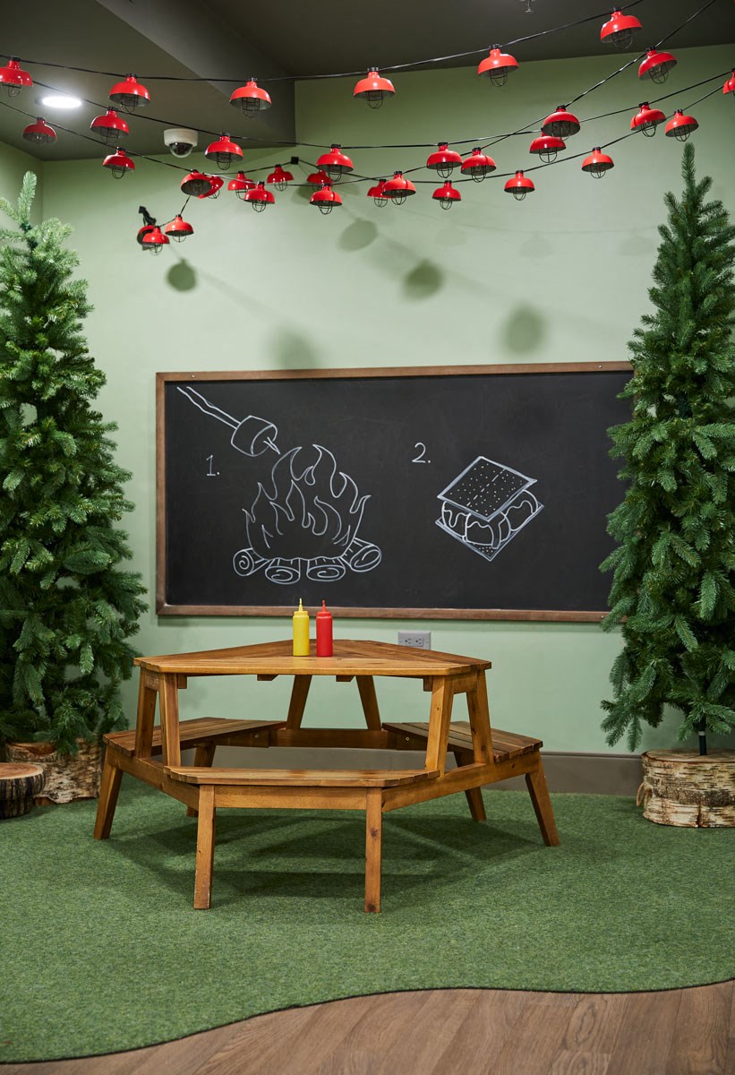 a classroom with a table and a chalkboard with christmas decorations