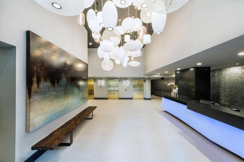 a large lobby with a large chandelier and a long bench