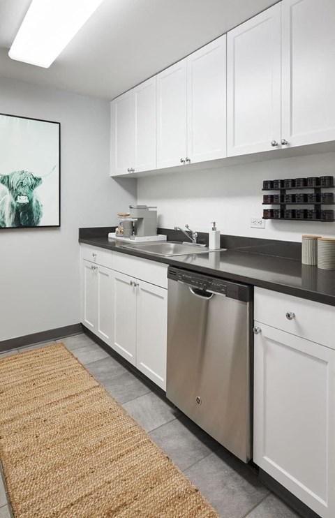 a kitchen with white cabinets and a stainless steel dishwasher