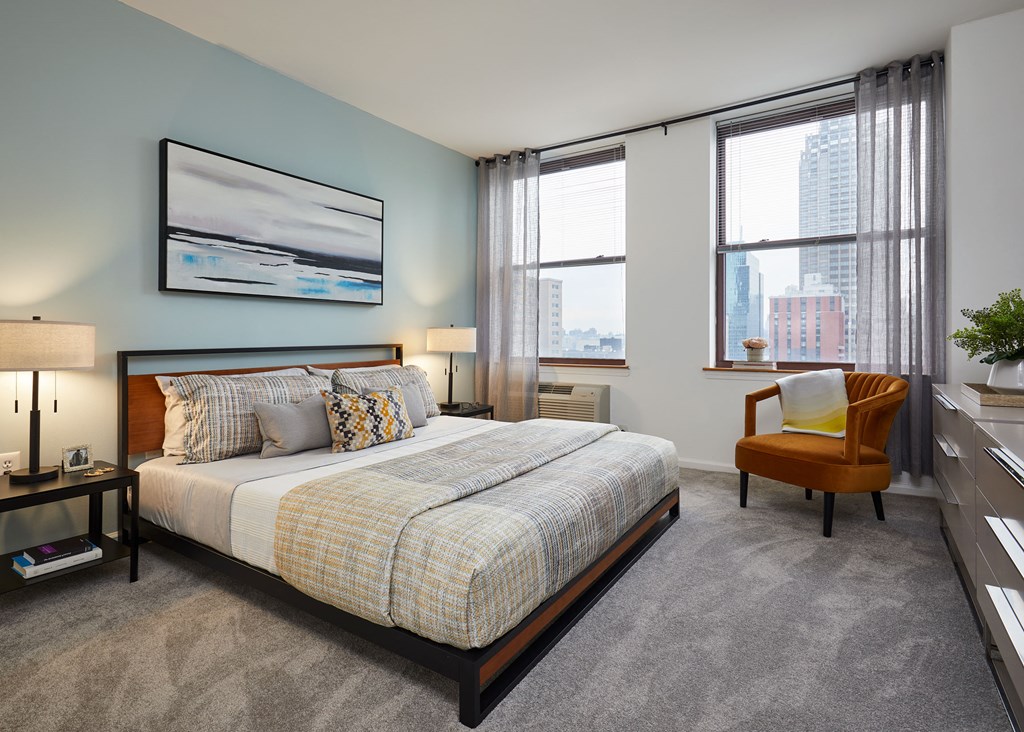 a bedroom with a bed and two windows