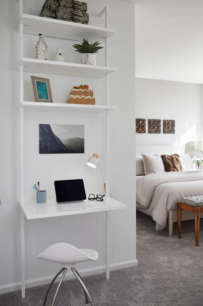 a white desk with a laptop on it in a bedroom