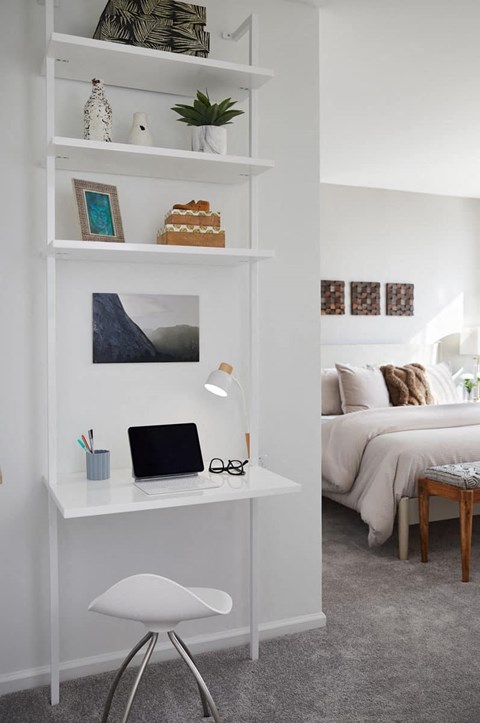 a white desk with a laptop on it in a bedroom
