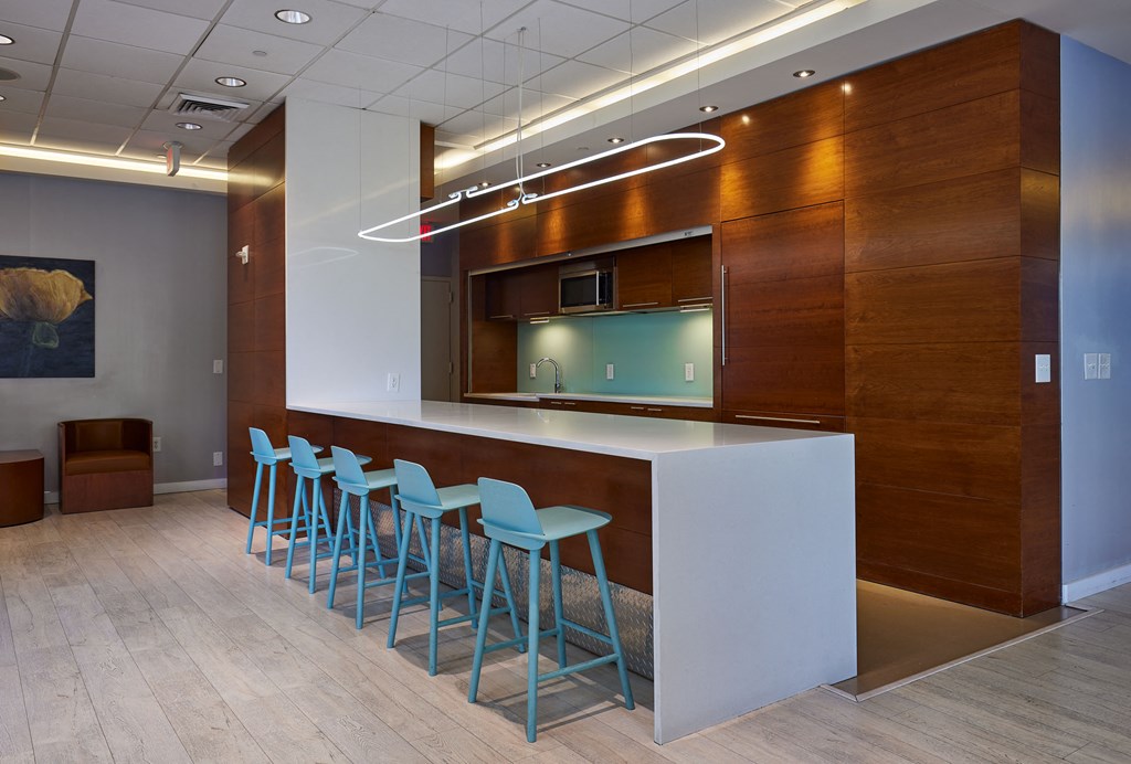 a kitchen with blue stools in front of a white counter
