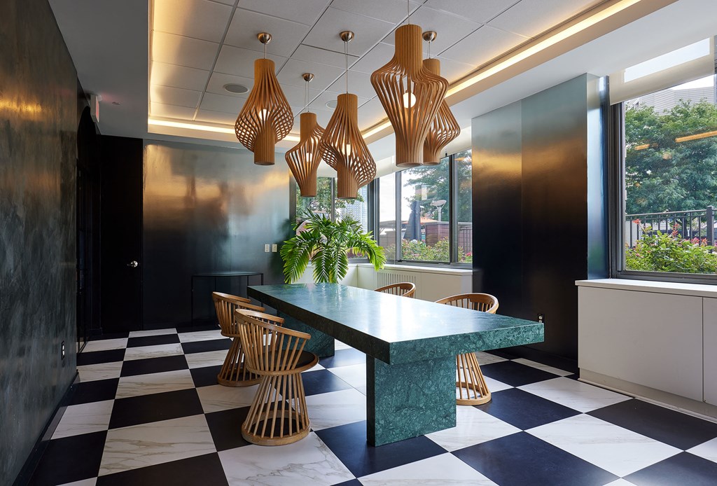 a dining room with black and white checkered floors and a green marble table