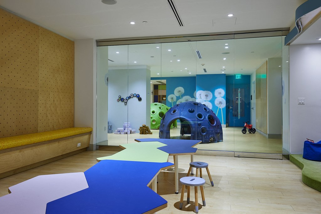 a childrens play room with blue and white tables and stools