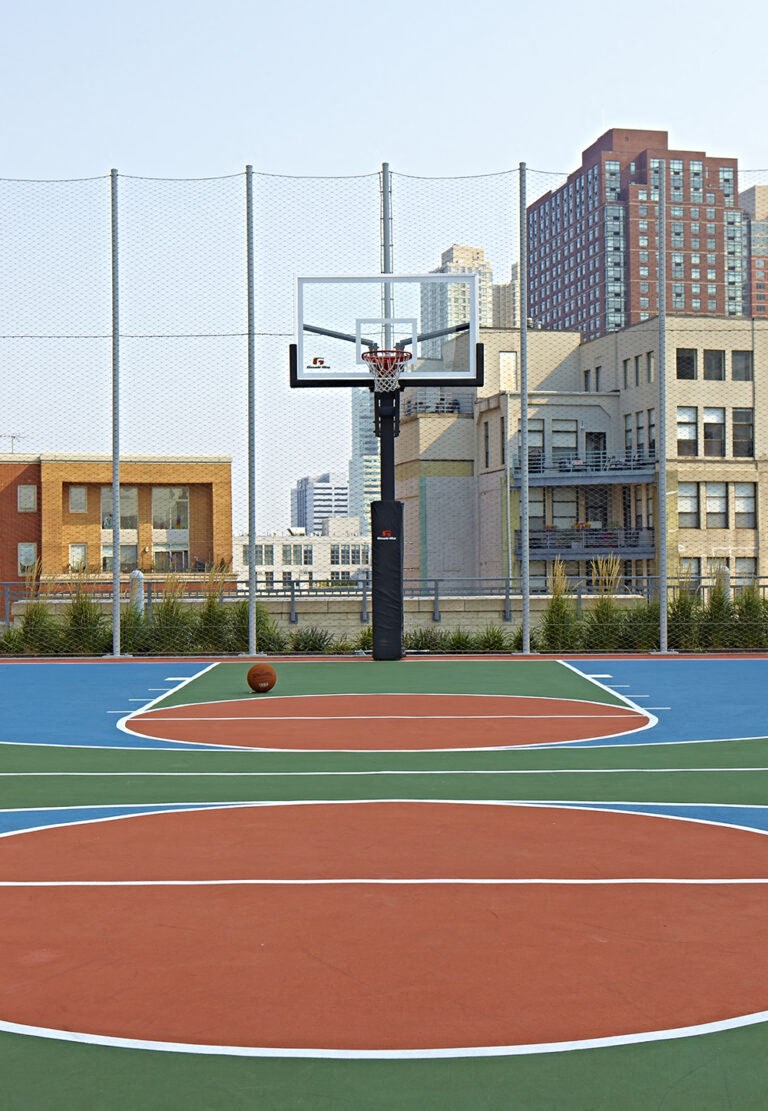 a basketball court with buildings in the background