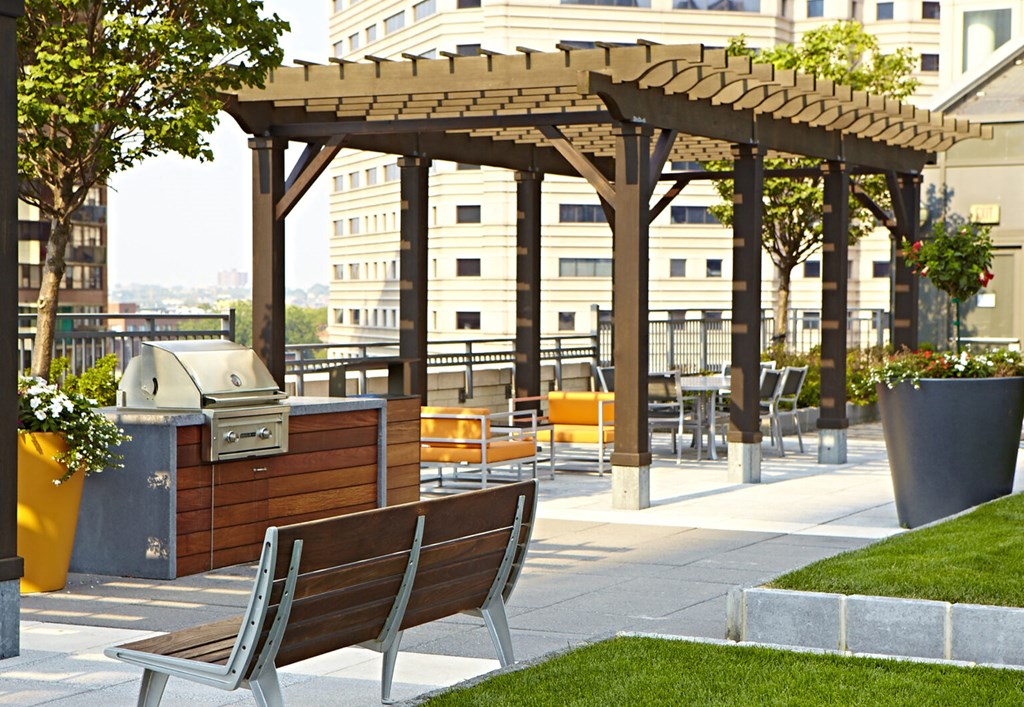 a picnic area with benches and a pergola on a rooftop
