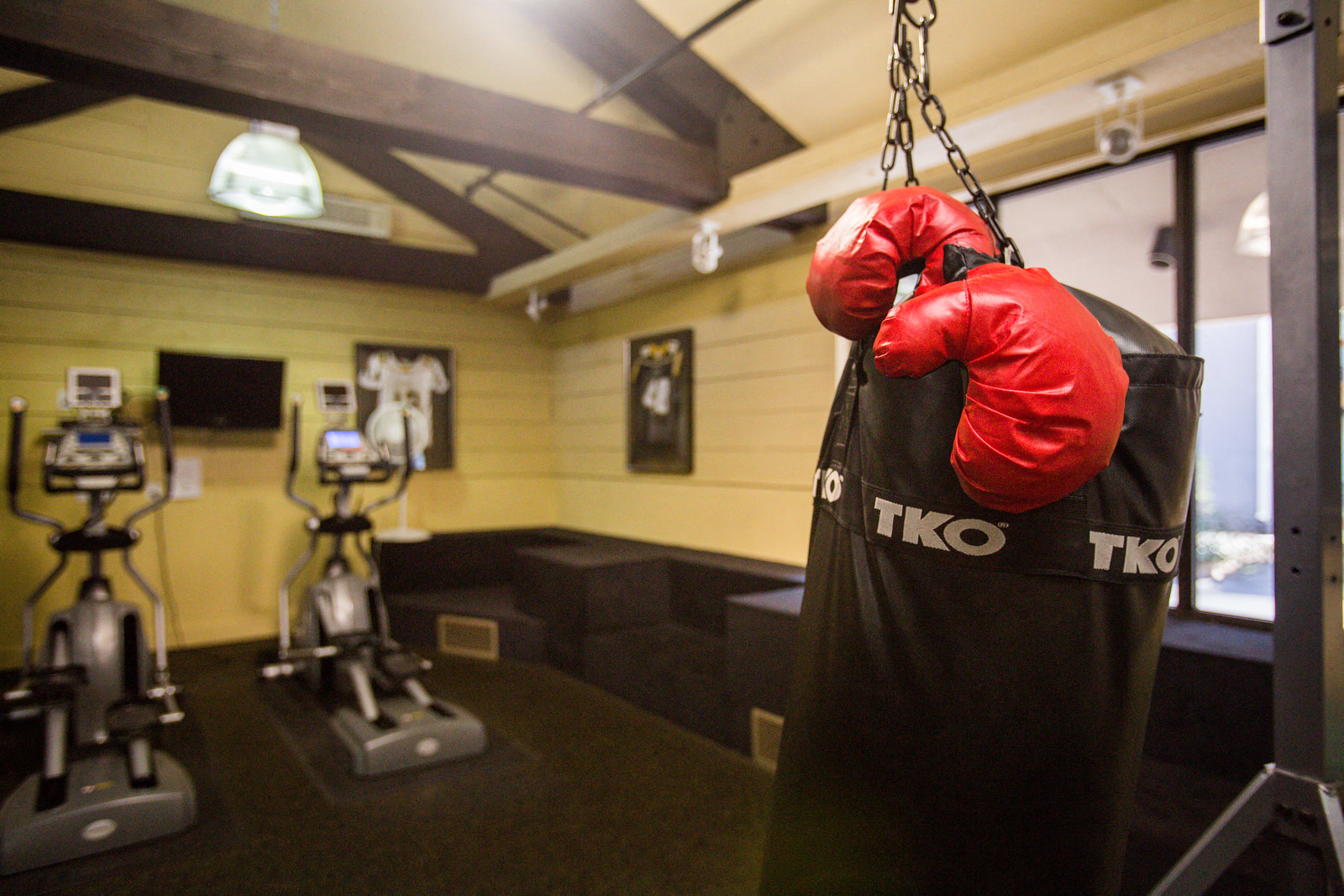 a pair of boxing gloves hanging from a punching bag in a gym
