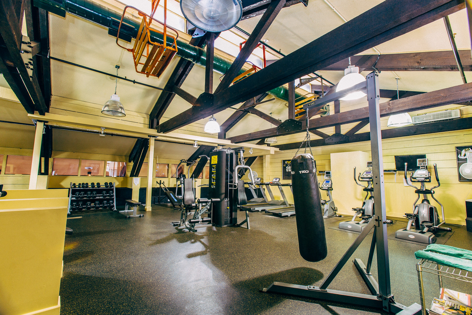 a gym with weights and a punching bag in it
