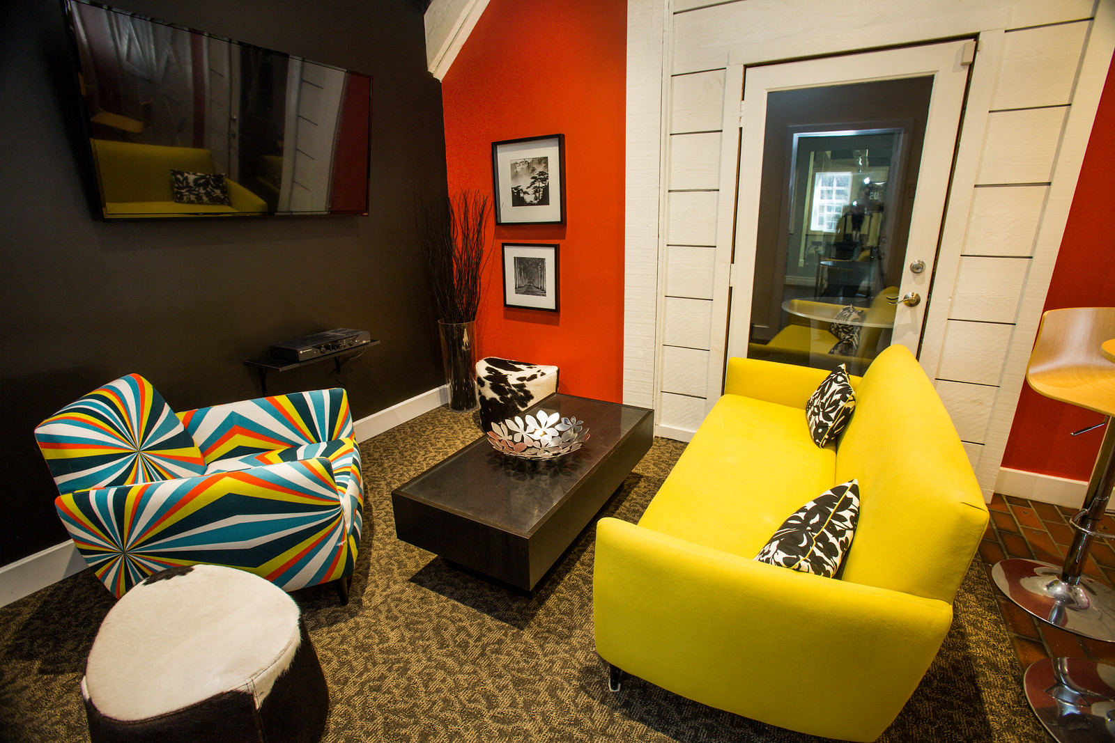 a living room with yellow furniture and an orange wall