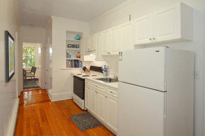a kitchen with white cabinets and a refrigerator