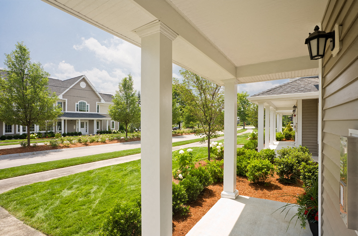a view of the front porch of a house with a lawn and a street