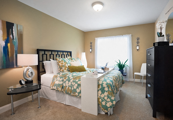 a bedroom with a bed and a dresser and a window