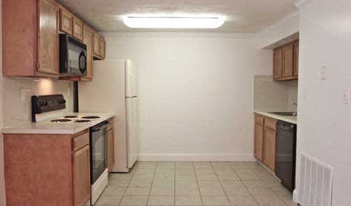 an empty kitchen with a stove and a refrigerator