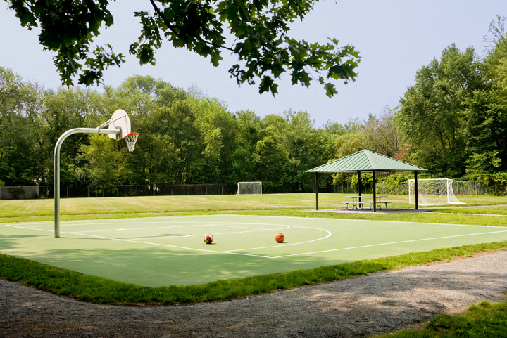 a basketball court in a park with a gazebo