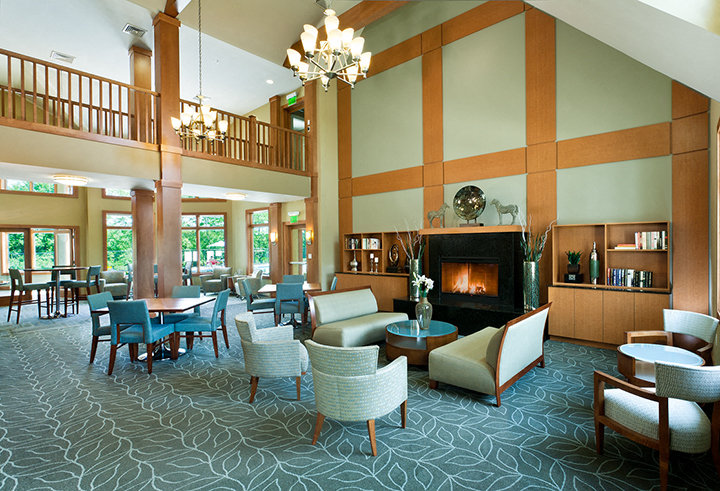 a large lobby with chairs and tables and a fireplace