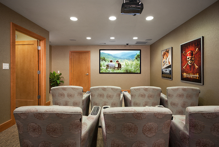 a large screening room with chairs and a television on the wall