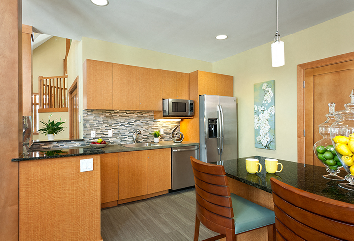 a kitchen with a island and a counter with chairs