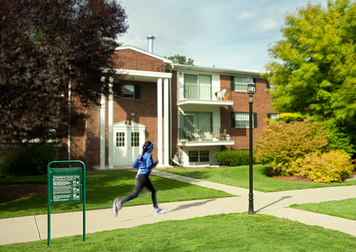 a woman running on a sidewalk in front of an apartment building