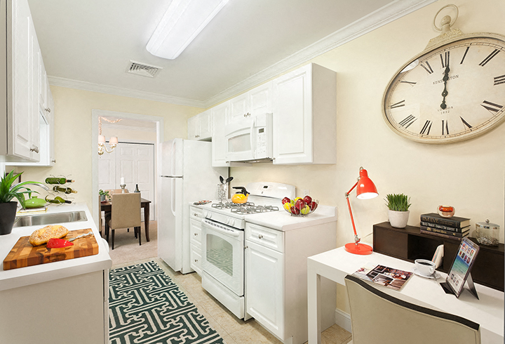 a white kitchen with a large clock on the wall