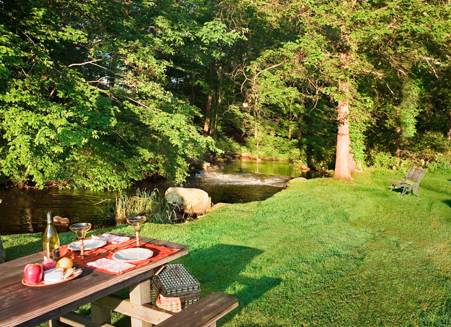a picnic table in a backyard next to a river