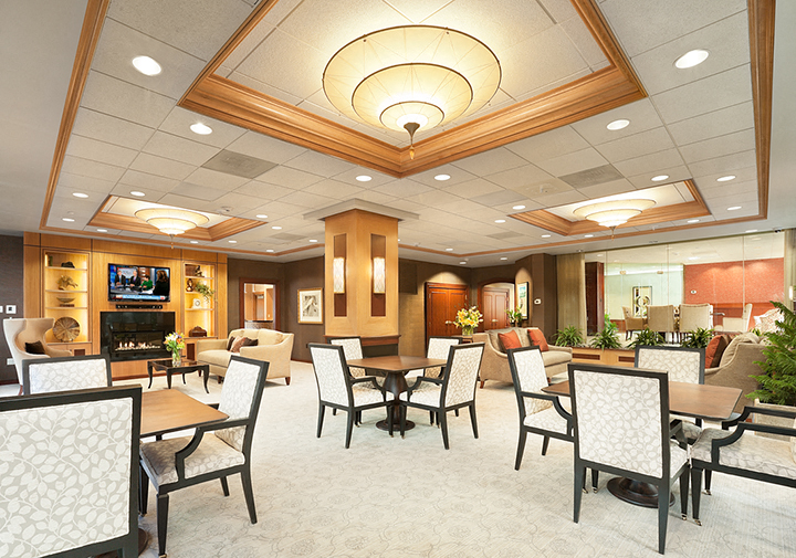 a large dining room with tables and chairs and a fireplace