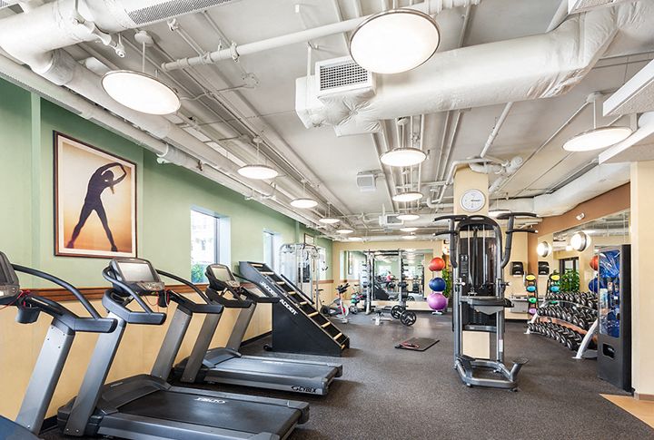 a gym with treadmills and other cardio equipment and weights
