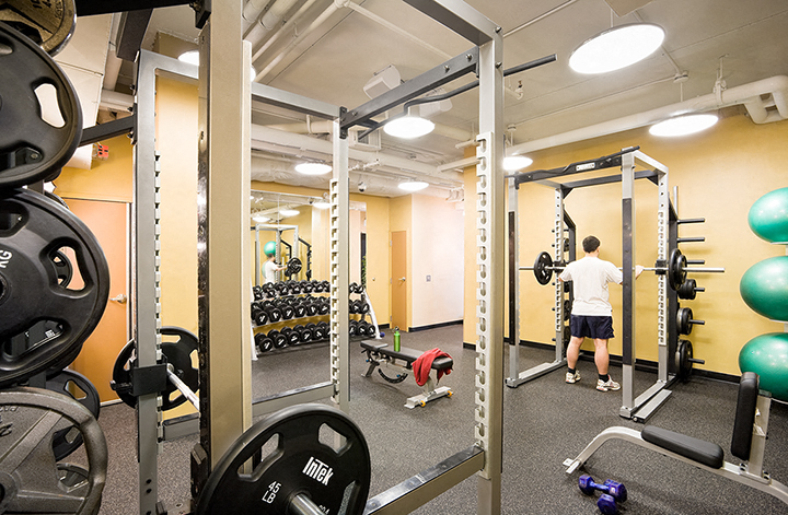 a man working out in a gym with weights and other equipment