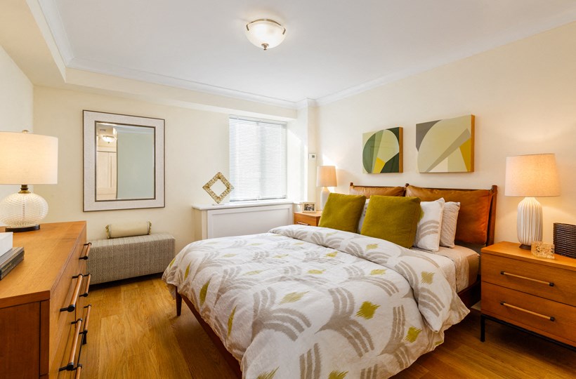 a bedroom with a bed and a desk and a window