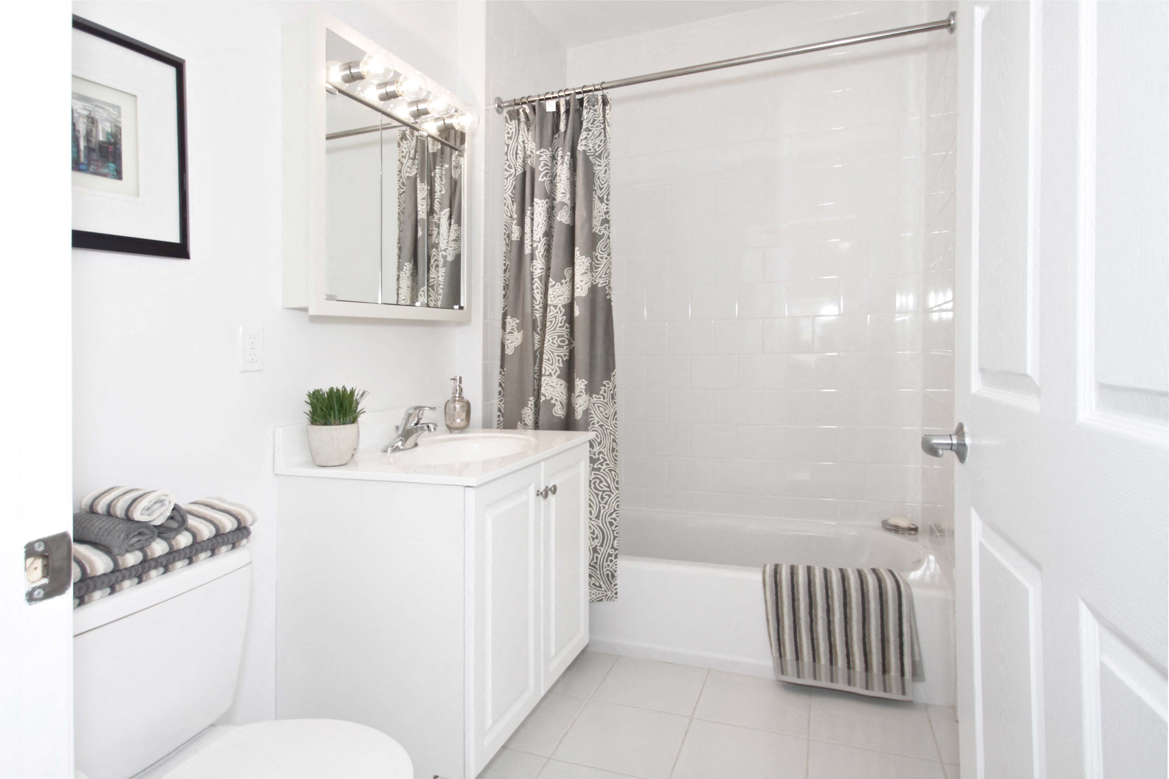 a white bathroom with a shower and a sink