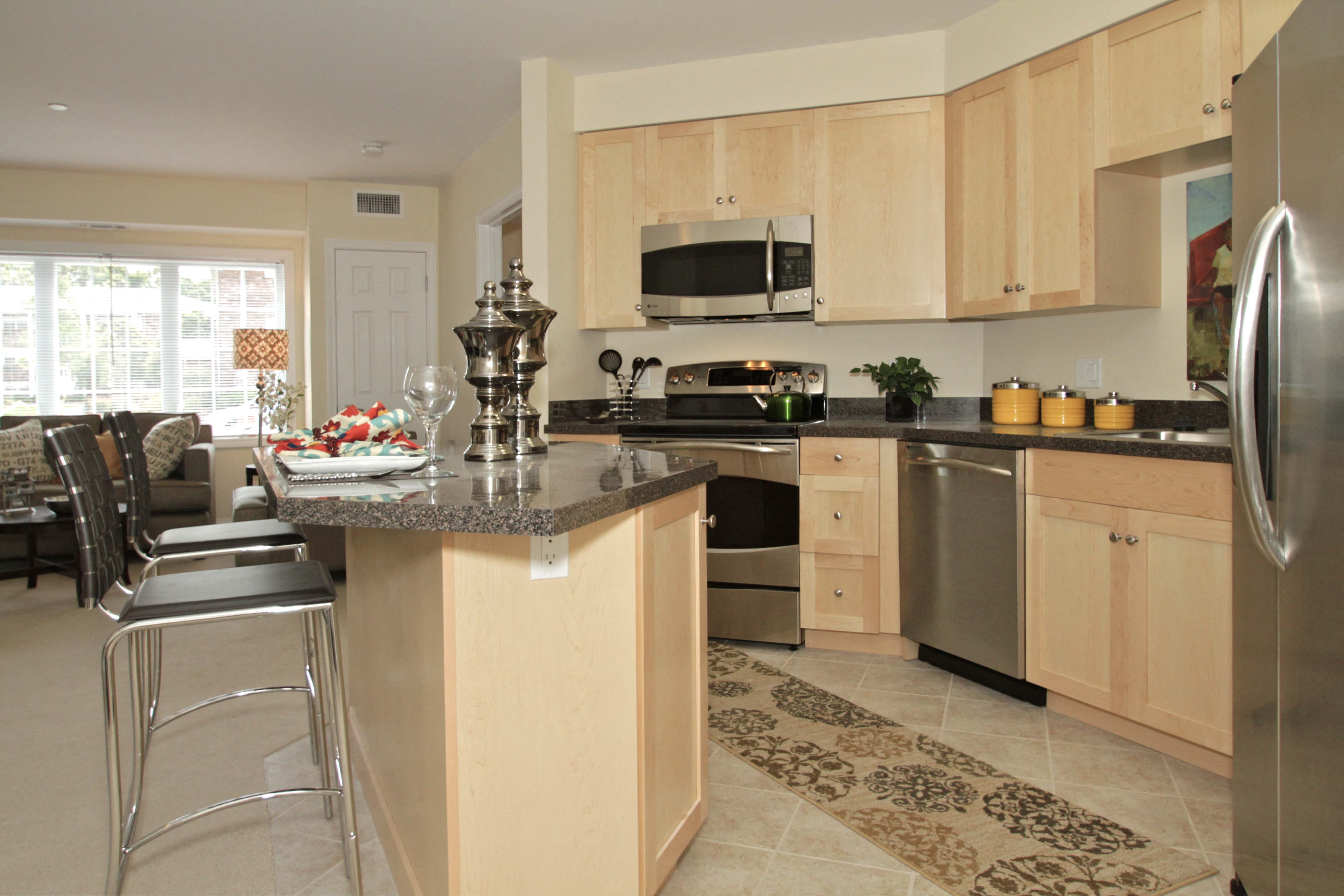 a large kitchen with stainless steel appliances and granite counter tops