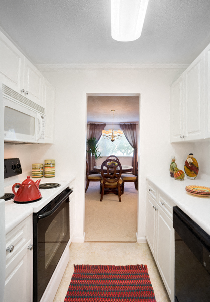 a kitchen with a view of a dining room and a table in the distance