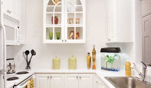 a white kitchen with white cabinets and a sink