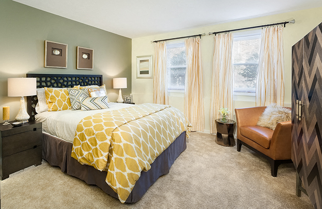 a bedroom with a bed and two windows