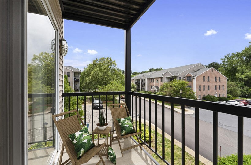 a balcony with two chairs and a view of a building