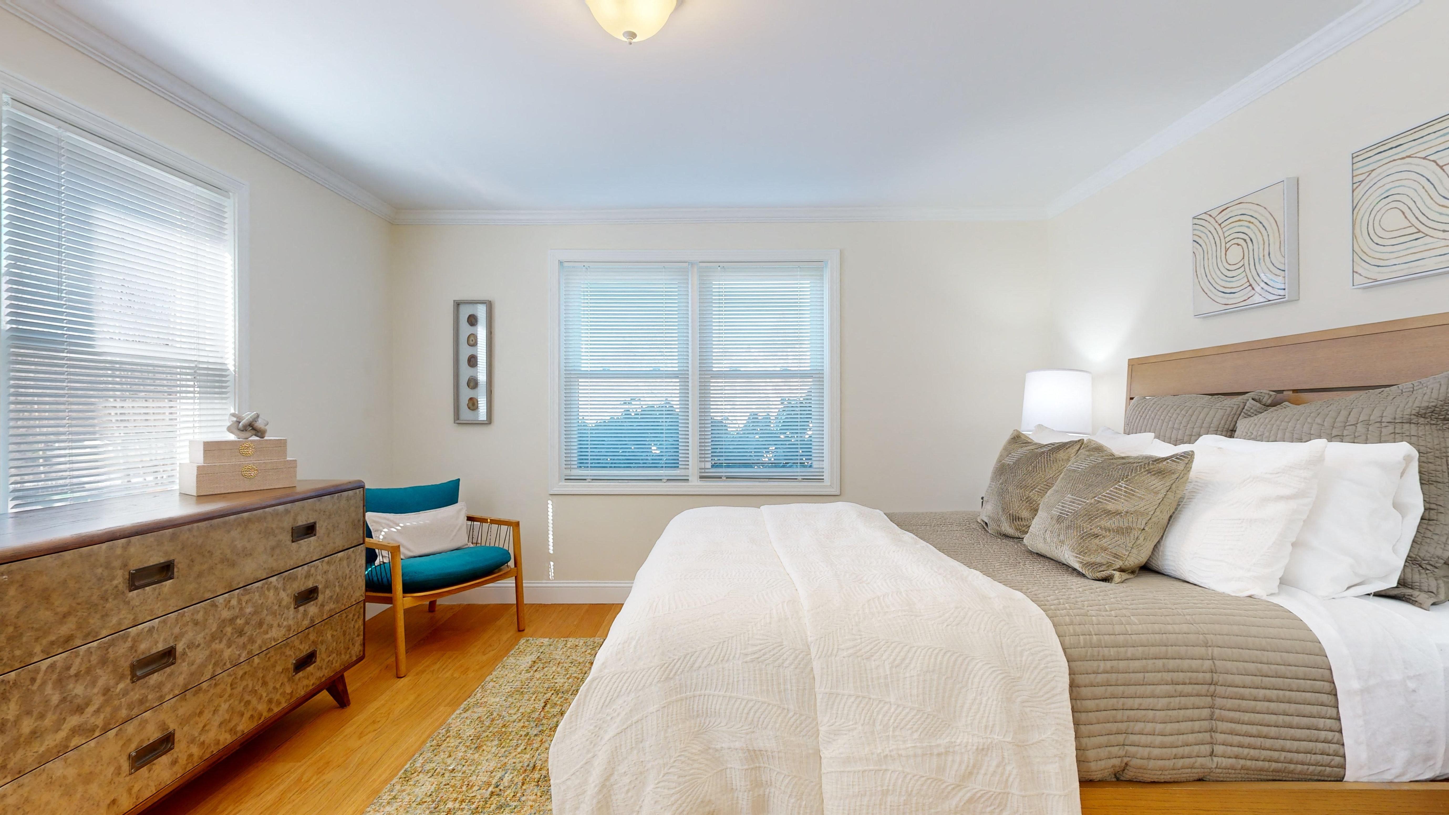 a bedroom with a bed and a dresser and a window