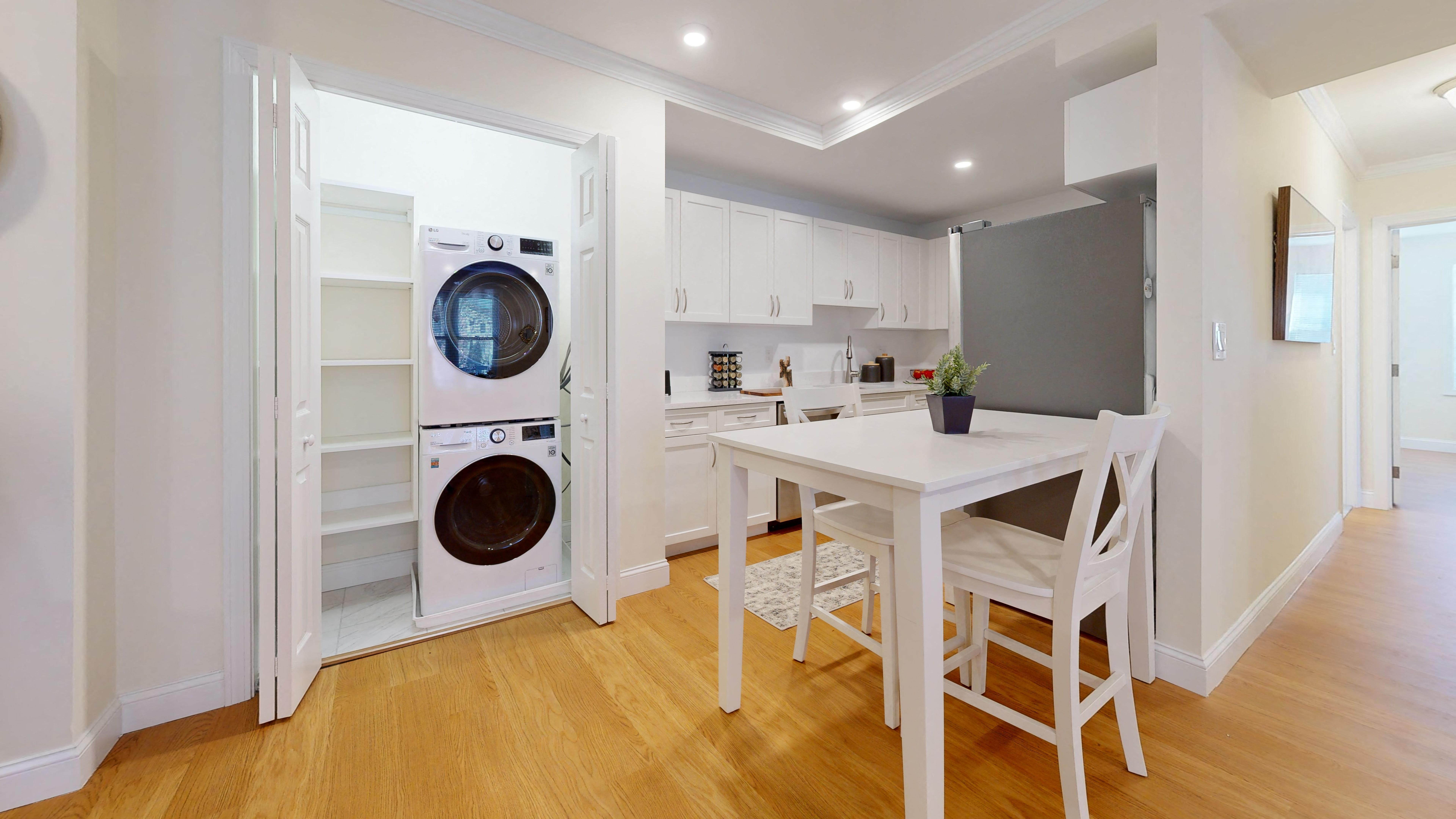 a kitchen with a washing machine and a table with chairs