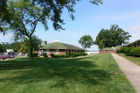 A house with a green lawn in front of it.