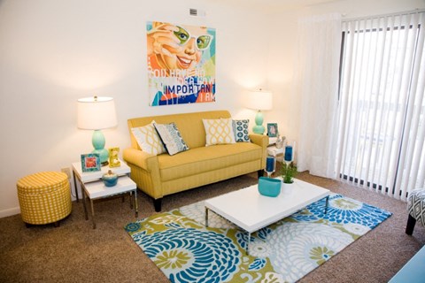 a living room with a yellow couch and a coffee table