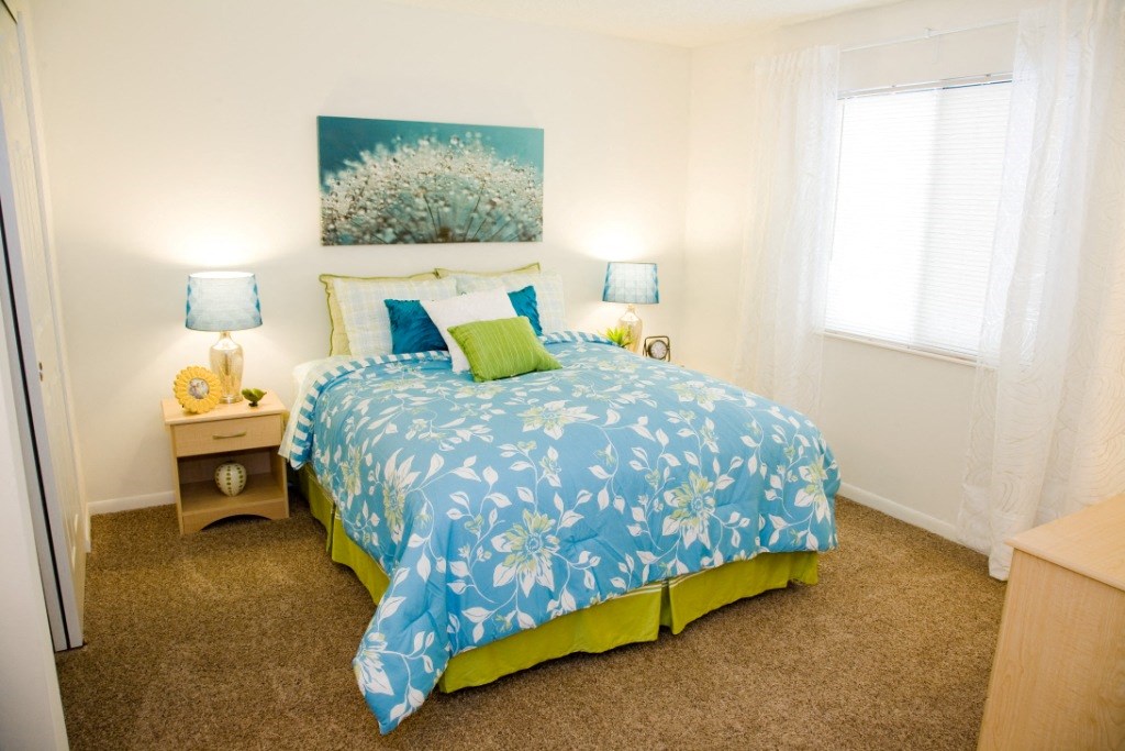 a bedroom with a bed and two lamps and a window