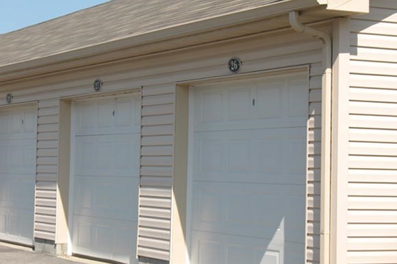 two garage doors on the side of a white building