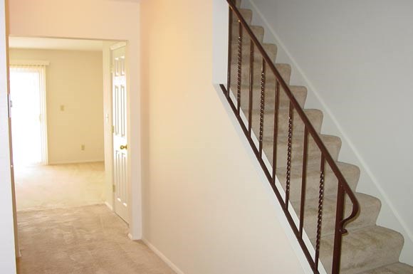 a staircase in a house with a hallway and a door