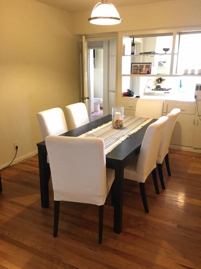 a dining room with a black table and white chairs