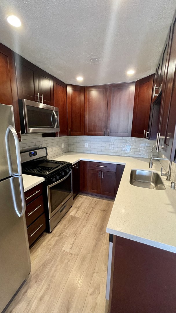 a kitchen with wooden cabinets and stainless steel appliances